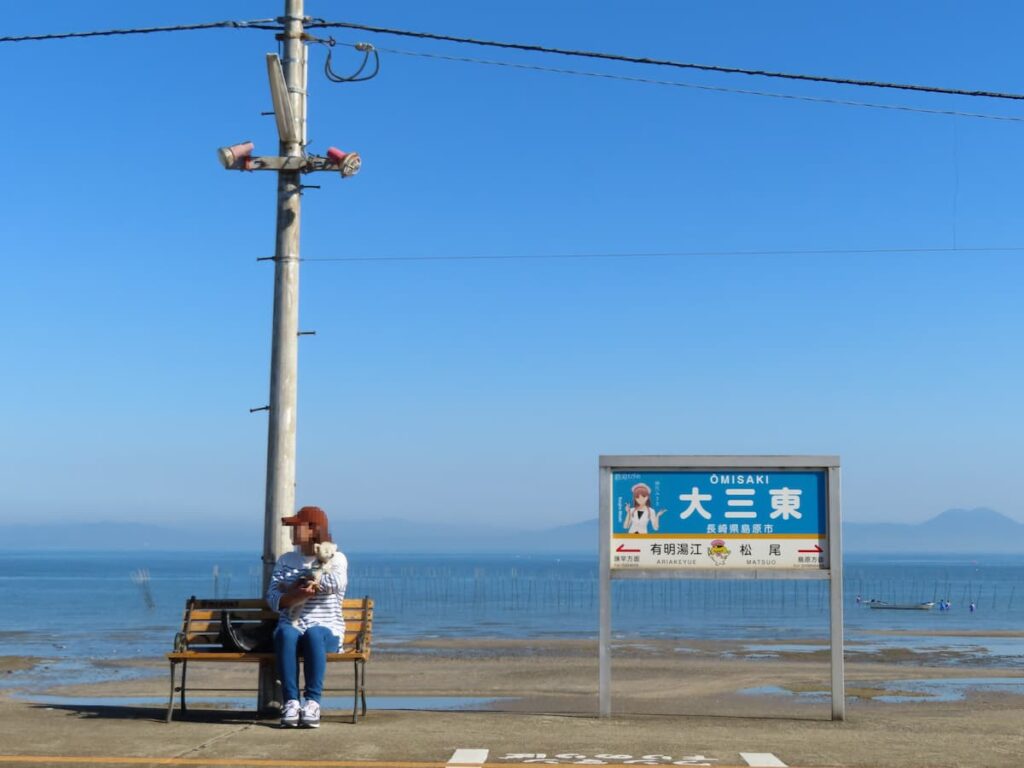 ホームのベンチに腰掛けるママと犬